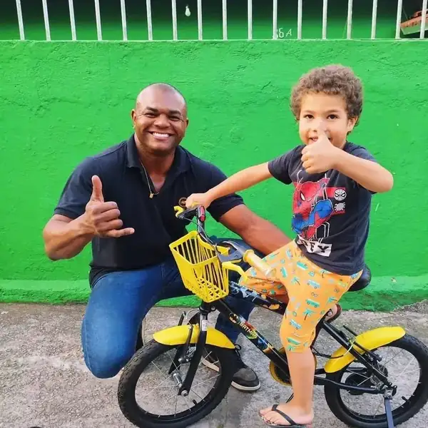 Pai e filho com bicicleta infantil amarela entregue pela loja
